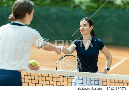 Adult woman tennis player shaking hands with her opponent Adult woman tennis player shaking hands with her opponent 138292073