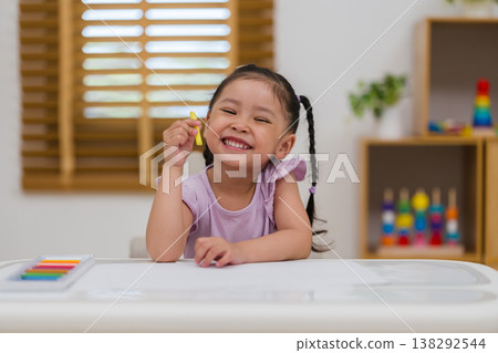 happy preschool child girl drawing and painting with colorful oil pastels on paper happy preschool child girl drawing and painting with colorful oil pastels on paper 138292544