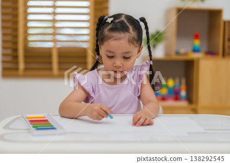 preschool child girl drawing and painting with colorful oil pastels on paper preschool child girl drawing and painting with colorful oil pastels on paper 138292545