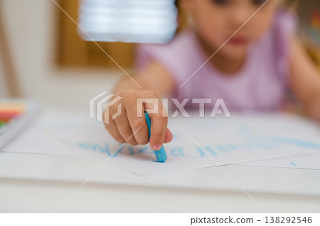close up preschool child girl drawing and painting with colorful oil pastels on paper 138292546