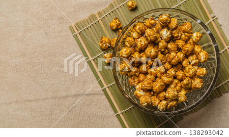 Caramel popcorn in a bowl on a bamboo mat for snack time Caramel popcorn in a bowl on a bamboo mat for snack time 138293042