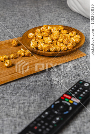 Snack time with popcorn and remote control on a couch Snack time with popcorn and remote control on a couch 138293059