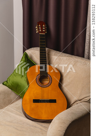 Guitar resting on a couch in a living room in the evening Guitar resting on a couch in a living room in the evening 138293112