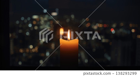 Close up of a thick burning candle with a vibrant golden flame against a shimmering night city bokeh background. Close up of a thick burning candle with a vibrant golden flame against a shimmering night city bokeh background. 138293299
