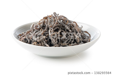 A side view of salted kelp served on a small white plate. 138293564