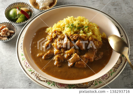 A close-up of chicken and beef curry with plenty of meat, served over saffron rice. 138293716
