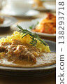 A close-up of chicken and beef curry with plenty of meat, served over saffron rice. 138293718