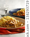 A close-up of chicken and beef curry with plenty of meat, served over saffron rice. 138293719