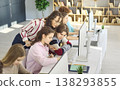 Teacher guiding teen students at computers in classroom lab, collaborative learning 138293855