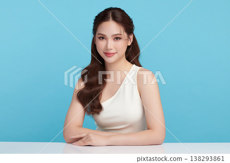 A beautiful young Asian woman with clean, fresh skin against a blue background. Skincare, facial treatment, cosmetology, beauty, and spa. An elegant portrait of an Asian woman. A beautiful young Asian woman with clean, fresh skin against a blue background. Skincare, facial treatment, cosmetology, beauty, and spa. An elegant portrait of an Asian woman. 138293861