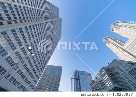 A wide-angle, low-angle photograph looking up at the skyscrapers of Nishi-Shinjuku and the Tokyo Metropolitan Government Building. A wide-angle, low-angle photograph looking up at the skyscrapers of Nishi-Shinjuku and the Tokyo Metropolitan Government Building. 138293987