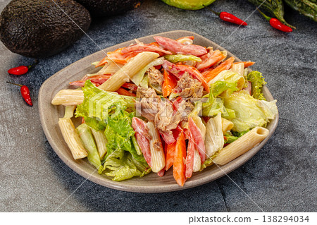Hearty pasta salad with tuna and fresh vegetables on a dark, textured surface 138294034