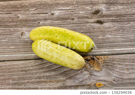 Two whole ripe white cucumbers on a dark textured stone background. Two whole ripe white cucumbers on a dark textured stone background. 138294036
