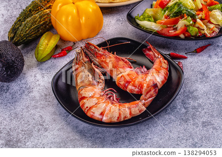 Grilled giant red prawns in a pan with fresh avocado, bell pepper, and salad on a stone table 138294053