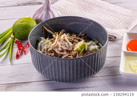 Vietnamese pho bo noodle soup with beef, rice noodles, and fresh ingredients 138294119
