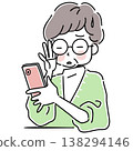 一位患有老花眼的老婦人瞇著眼睛操作智慧型手機。 138294146