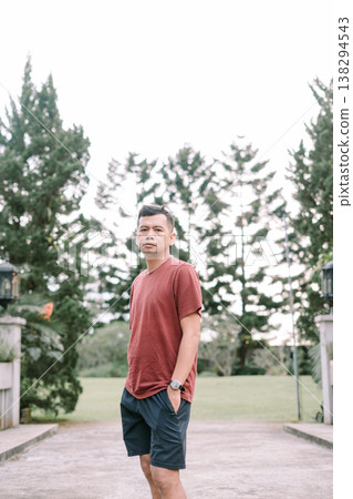 Casual Southeast Asian man posing slightly tilted with hands in pockets outdoors Casual Southeast Asian man posing slightly tilted with hands in pockets outdoors 138294543
