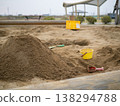 A scene from a park with sandcastles and a yellow bucket, showing signs of sand play. 138294788