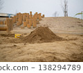 A bucket and shovel placed in a park sandbox | A scene that evokes the feeling of children playing. 138294789