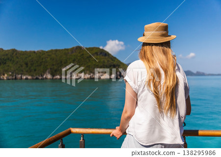 Young woman standing on boat deck and looking at tropical islands in Ang Thong marine park Thailand Young woman standing on boat deck and looking at tropical islands in Ang Thong marine park Thailand 138295986