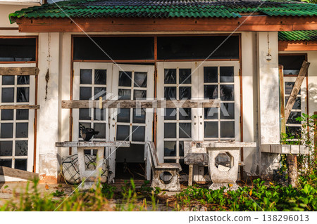 Abandoned beachfront house with boarded doors and windows symbolizing bankruptcy and business failure 138296013