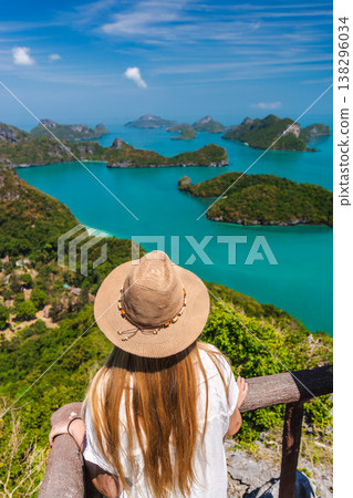 Young woman looking at tropical islands in Angthong National Marine Park from scenic viewpoint 138296034
