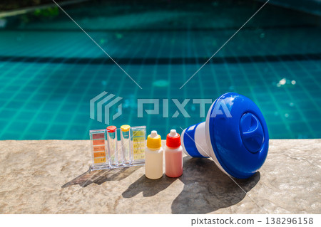 Pool water testing kit and chemical dispenser on pool edge for swimming pool maintenance and sanitation 138296158