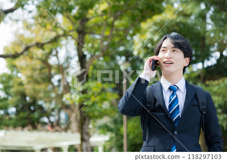 手持智慧型手機的年輕商人 手持智慧型手機的年輕商人 138297103