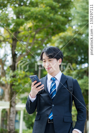 手持智慧型手機的年輕商人 手持智慧型手機的年輕商人 138297111