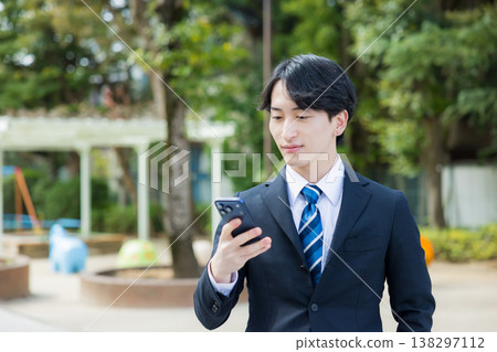 手持智慧型手機的年輕商人 138297112