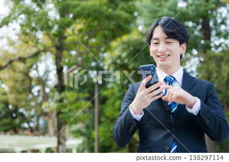 手持智慧型手機的年輕商人 手持智慧型手機的年輕商人 138297114