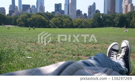 Teen boy, girl in jeans and gumshoes, grass in Central Park, New York USA. Young teenagers sneakers. 138297269