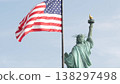 Statue of Liberty on Liberty Island, New York, USA. Flag and monument, patriotic symbol of democracy 138297498
