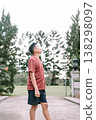 Southeast Asian man looking sideways and up in relaxed outdoor setting 138298097