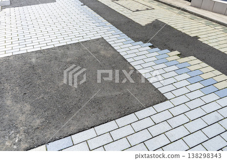 The brick sidewalk has been temporarily repaired with asphalt due to construction work - patched up. The brick sidewalk has been temporarily repaired with asphalt due to construction work - patched up. 138298343