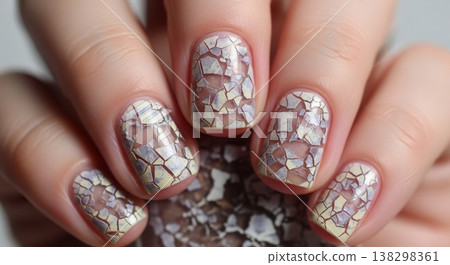 Extreme close-up of fingernails featuring a decorative mosaic crackle effect in pale yellow and iridescent blue tones. Extreme close-up of fingernails featuring a decorative mosaic crackle effect in pale yellow and iridescent blue tones. 138298361