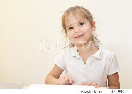 Caucasian young female child in white shirt drawing with pencils indoors Caucasian young female child in white shirt drawing with pencils indoors 138299014