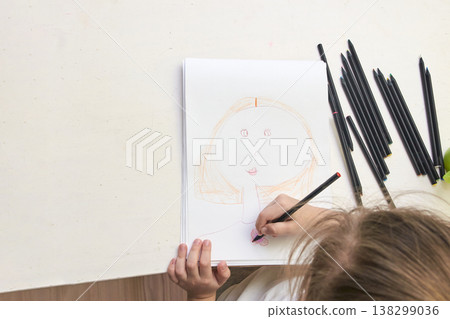 Caucasian child drawing with colored pencils on white paper at home art activity Caucasian child drawing with colored pencils on white paper at home art activity 138299036