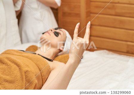Young Caucasian Woman Relaxing In A Spa With Eye Patches And Towel, Expressing Peace And Relaxation Young Caucasian Woman Relaxing In A Spa With Eye Patches And Towel, Expressing Peace And Relaxation 138299060