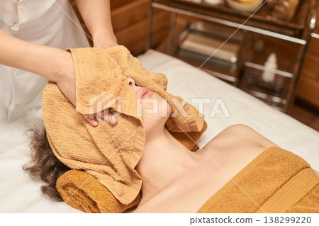 Relaxing Spa Facial Treatment For Young Caucasian Woman With Warm Towel Therapy In A Serene 138299220