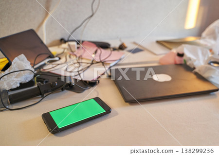 Messy Workspace With Laptop, Smartphone, Chargers, And Stationery Reflecting A Busy Lifestyle 138299236
