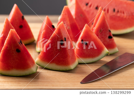 Sliced fresh watermelon and knife on cutting wooden board, healthy tropical fruit for summer season Sliced fresh watermelon and knife on cutting wooden board, healthy tropical fruit for summer season 138299299