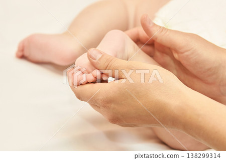 Caucasian Female Hands Gently Holding Baby Foot, Symbolizing Care And Tenderness In Parenting Caucasian Female Hands Gently Holding Baby Foot, Symbolizing Care And Tenderness In Parenting 138299314