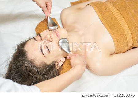 Young Caucasian Female Receiving Facial Gua Sha Massage For Relaxation And Skin Rejuvenation 138299370