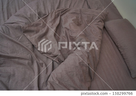 Crumpled purple bed linens creating a cozy and relaxed bedroom atmosphere Crumpled purple bed linens creating a cozy and relaxed bedroom atmosphere 138299766