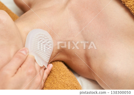 Female Applying Exfoliating Brush To Neck And Shoulder For Skin Care And Relaxation Female Applying Exfoliating Brush To Neck And Shoulder For Skin Care And Relaxation 138300050