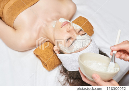 Young Caucasian Female Relaxing With A Facial Mask At A Spa For Skincare And Rejuvenation Young Caucasian Female Relaxing With A Facial Mask At A Spa For Skincare And Rejuvenation 138300052