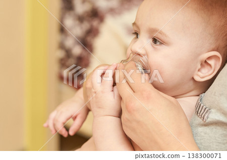 Caucasian Baby With Pacifier Held By Female Caregiver In Close-Up Moment Of Comfort 138300071