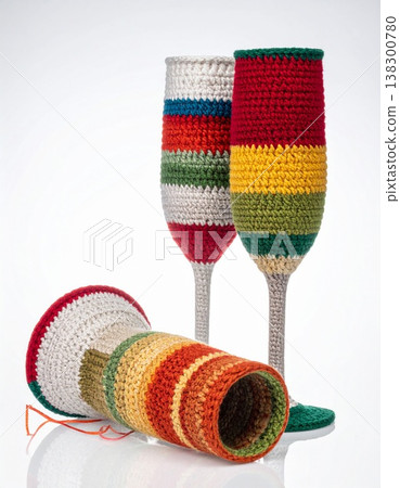 Three Knitted Champagne Flutes with Striped Colorful Cozy on White Background 138300780