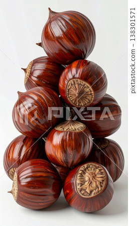 Pile of Glossy Brown Chestnuts Stacked in a Pyramid Shape on Seamless White Background 138301571